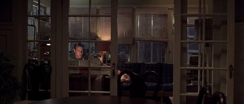 Movie still from “Frequency” (2000), directed by Gregory Hoblit – A man and a woman laying on a couch in front of a window; Wide shot, High angle