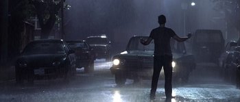 Movie still from “Frequency” (2000), directed by Gregory Hoblit – A man standing in the middle of the street in the rain; Wide shot, Low angle