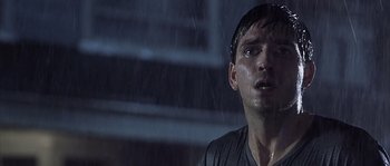 Movie still from “Frequency” (2000), directed by Gregory Hoblit – A young man with wet hair and a head band in the rain; Close Up shot, Low angle
