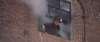 Movie still from “Frequency” (2000), directed by Gregory Hoblit – A fire fighter is looking out of a window; Medium shot, Low angle