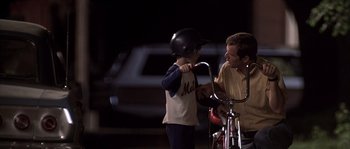 Movie still from “Frequency” (2000), directed by Gregory Hoblit – A man and a boy with a helmet and a bicycle; Medium shot, Over the shoulder angle