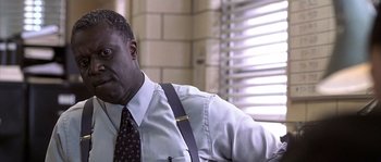 Movie still from “Frequency” (2000), directed by Gregory Hoblit – A man sitting in a chair wearing a tie; Close Up shot, Low angle