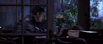 Movie still from “Frequency” (2000), directed by Gregory Hoblit – A man sitting at a desk looking at a computer screen; Medium shot, Low angle