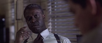 Movie still from “Frequency” (2000), directed by Gregory Hoblit – A man in a suit and tie looking at the camera; Close Up shot, Low angle