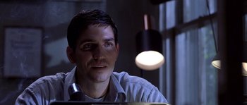 Movie still from “Frequency” (2000), directed by Gregory Hoblit – A person sitting at a desk; Close Up shot, Over the shoulder angle