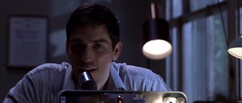 Movie still from “Frequency” (2000), directed by Gregory Hoblit – A man sitting in front of a microphone in front of a mirror; Close Up shot, Over the shoulder angle