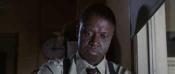 Movie still from “Frequency” (2000), directed by Gregory Hoblit – A person wearing a suit and tie; Close Up shot, Low angle