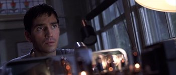 Movie still from “Frequency” (2000), directed by Gregory Hoblit – A man sitting in front of a table with candles; Close Up shot, Over the shoulder angle