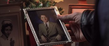 Movie still from “Frequency” (2000), directed by Gregory Hoblit – A person holding a picture of a man in a suit; Extreme Close Up shot, High angle