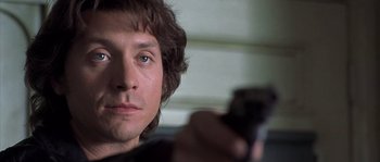 Movie still from “Frequency” (2000), directed by Gregory Hoblit – A person holding a gun; Close Up shot, Low angle