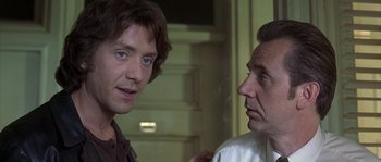 Movie still from “Frequency” (2000), directed by Gregory Hoblit – Two men talking to each other in front of a wall; Close Up shot, Over the shoulder angle