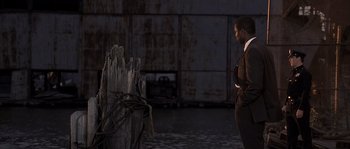 Movie still from “Frequency” (2000), directed by Gregory Hoblit – A man standing next to a wooden post; Wide shot, Over the shoulder angle