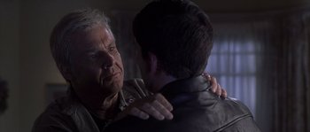 Movie still from “Frequency” (2000), directed by Gregory Hoblit – An older man and a younger man are hugging; Close Up shot, Over the shoulder angle