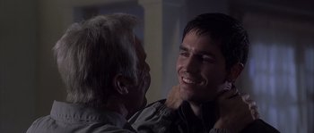 Movie still from “Frequency” (2000), directed by Gregory Hoblit – An older man and a younger man smiling for the camera; Close Up shot, Over the shoulder angle