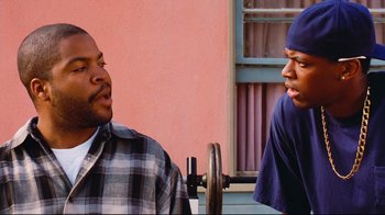 Movie still from “Friday” (1995), directed by F. Gary Gray – Two men sitting next to each other in front of a building; Close Up shot, Over the shoulder angle