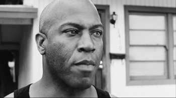 Movie still from “Friday” (1995), directed by F. Gary Gray – A black and white photo of a bald man; Close Up shot, Low angle