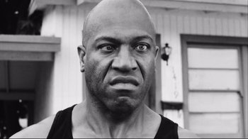 Movie still from “Friday” (1995), directed by F. Gary Gray – A black and white photo of a man with a bald head; Close Up shot, Low angle