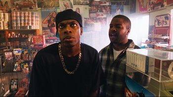 Movie still from “Friday” (1995), directed by F. Gary Gray – Two men standing next to each other in a room; Medium shot, Low angle
