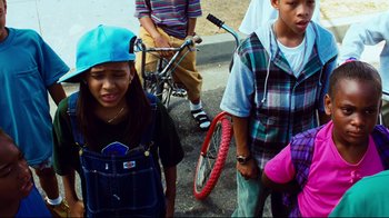 Movie still from “Friday” (1995), directed by F. Gary Gray – A group of young people standing next to each other; Medium shot, High angle