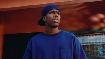 Movie still from “Friday” (1995), directed by F. Gary Gray – A man in a blue shirt and a hat; Close Up shot, Low angle