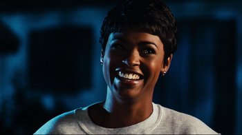 Movie still from “Friday” (1995), directed by F. Gary Gray – A person with short black hair smiling; Close Up shot, Over the shoulder angle