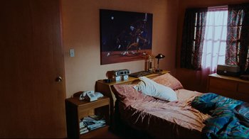 Movie still from “Friday” (1995), directed by F. Gary Gray – A bedroom with a bed , nightstand , lamp and a painting on the wall; Wide shot, High angle