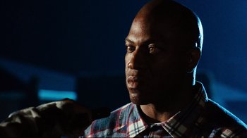 Movie still from “Friday” (1995), directed by F. Gary Gray – A person wearing a plaid shirt; Close Up shot, Low angle