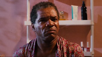 Movie still from “Friday” (1995), directed by F. Gary Gray – An older man in a red and white shirt is looking at the camera; Close Up shot, Low angle