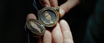 Movie still from “Friday the 13th” (2009), directed by Marcus Nispel – A person holding an old picture of a woman in an open case; Extreme Close Up shot, Overhead angle