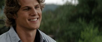 Movie still from “Friday the 13th” (2009), directed by Marcus Nispel – A person smiling with trees in the background; Close Up shot, Over the shoulder angle