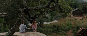 Movie still from “Friday the 13th” (2009), directed by Marcus Nispel – A woman holding a man's hand on top of a rock; Wide shot, Over the shoulder angle