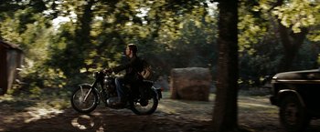 Movie still from “Friday the 13th” (2009), directed by Marcus Nispel – A man riding a motorcycle down a dirt road; Wide shot, Over the shoulder angle