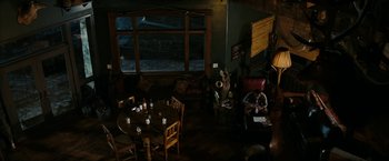 Movie still from “Friday the 13th” (2009), directed by Marcus Nispel – A room filled with tables and chairs next to a window; Extreme Wide shot, High angle