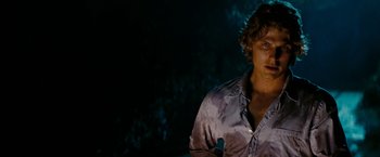 Movie still from “Friday the 13th” (2009), directed by Marcus Nispel – A man in a white shirt is standing in front of a tree; Close Up shot, Over the shoulder angle