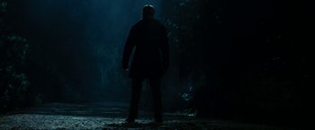 Movie still from “Friday the 13th” (2009), directed by Marcus Nispel – A man standing in the dark in front of a forest; Wide shot, Low angle