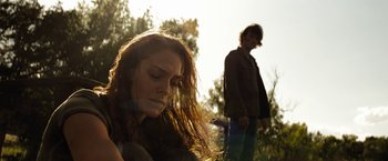 Movie still from “Friday the 13th” (2009), directed by Marcus Nispel – A woman sitting next to a man in a field; Close Up shot, Low angle