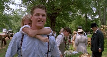 Movie still from “Fried Green Tomatoes” (1991), directed by Jon Avnet – A man and a little girl are standing in the grass; Medium shot, Low angle