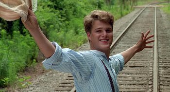 Movie still from “Fried Green Tomatoes” (1991), directed by Jon Avnet – A man standing on a train track with his arms outstretched; Medium shot, Low angle