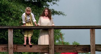 Movie still from “Fried Green Tomatoes” (1991), directed by Jon Avnet – A woman and a child standing on a wooden fence; Wide shot, Low angle