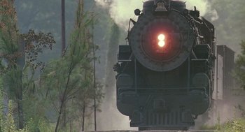 Movie still from “Fried Green Tomatoes” (1991), directed by Jon Avnet – A steam train traveling down the tracks near a forest; Extreme Wide shot, Low angle