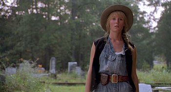 Movie still from “Fried Green Tomatoes” (1991), directed by Jon Avnet – A woman wearing a cowboy hat standing in a cemetery; Medium shot, Low angle