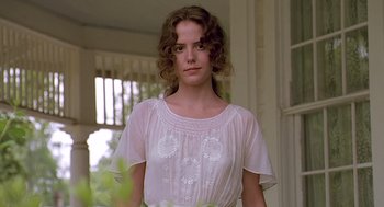 Movie still from “Fried Green Tomatoes” (1991), directed by Jon Avnet – A woman in a white dress standing in front of a window; Close Up shot, Low angle