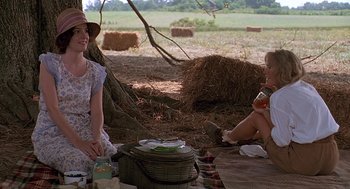 Movie still from “Fried Green Tomatoes” (1991), directed by Jon Avnet – Two women sitting on the ground in a field; Medium shot, Over the shoulder angle