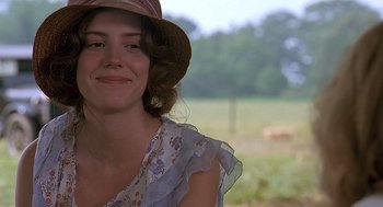 Movie still from “Fried Green Tomatoes” (1991), directed by Jon Avnet – A young woman wearing a sun hat in front of a field; Close Up shot, Over the shoulder angle