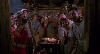 Movie still from “Fried Green Tomatoes” (1991), directed by Jon Avnet – A group of people standing in front of a birthday cake; Medium shot, Low angle