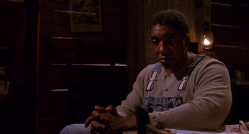 Movie still from “Fried Green Tomatoes” (1991), directed by Jon Avnet – A man sitting on a chair in a room; Medium shot, Over the shoulder angle