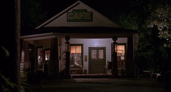 Movie still from “Fried Green Tomatoes” (1991), directed by Jon Avnet – A cafe is lit up at night in the dark; Wide shot, High angle