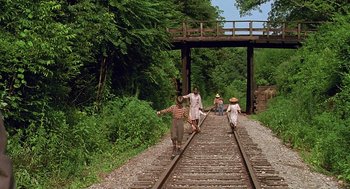 Movie still from “Fried Green Tomatoes” (1991), directed by Jon Avnet – A group of people walking along a train track; Wide shot, High angle