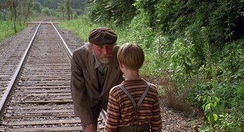 Movie still from “Fried Green Tomatoes” (1991), directed by Jon Avnet – An old man and a young boy are on the railroad tracks; Medium shot, Over the shoulder angle