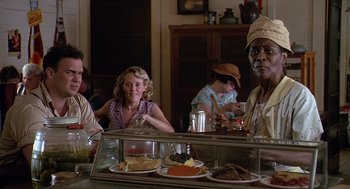 Movie still from “Fried Green Tomatoes” (1991), directed by Jon Avnet – A group of people sitting at a table with plates of food on it; Medium shot, Over the shoulder angle